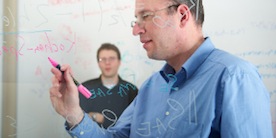 Dr. Lütkenhaus with student at whiteboard